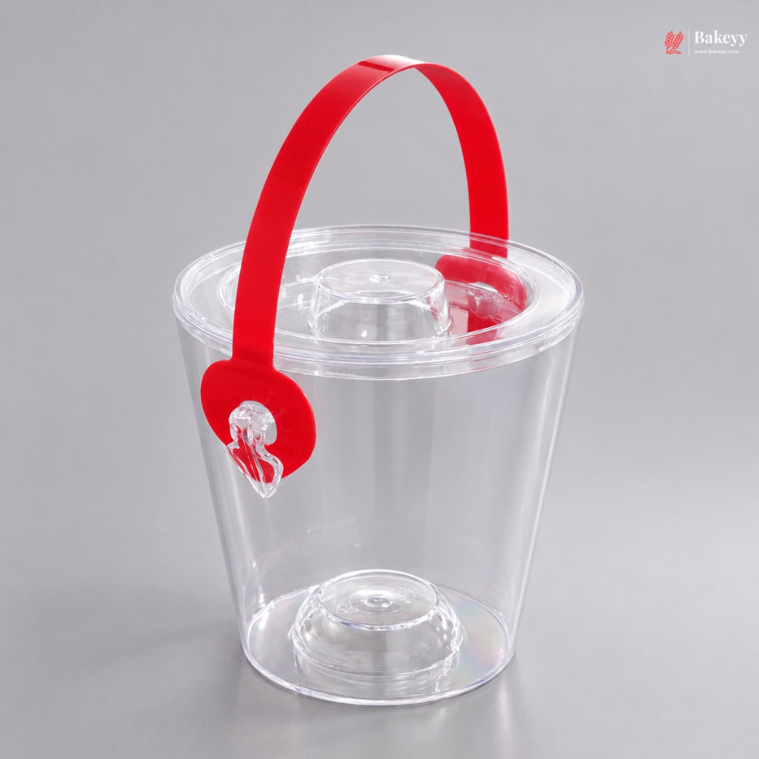 Clear plastic ice bucket with a red handle on a gray background