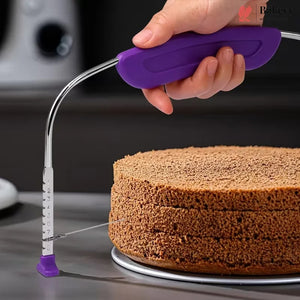 A hand holding a purple and silver cake level tool over a partially sliced round cake on a metal stand, with a blurred kitchen background.