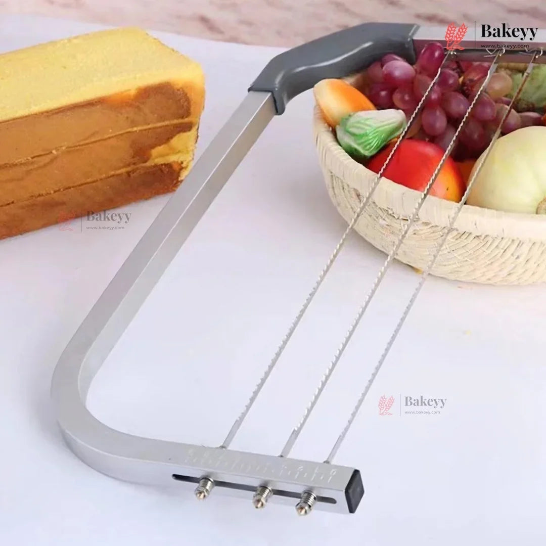 Metal lopper on a white surface with a block of cheese and a basket of fruits in the background.