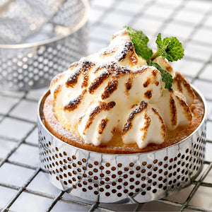 Dessert with meringue on a metal stand on a tiled surface