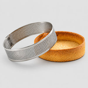 Metal cake ring with a baked cake on a light gray background