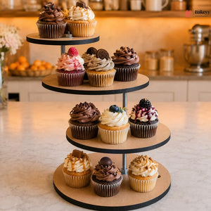 Three-tiered stand with various cupcakes on a kitchen counter