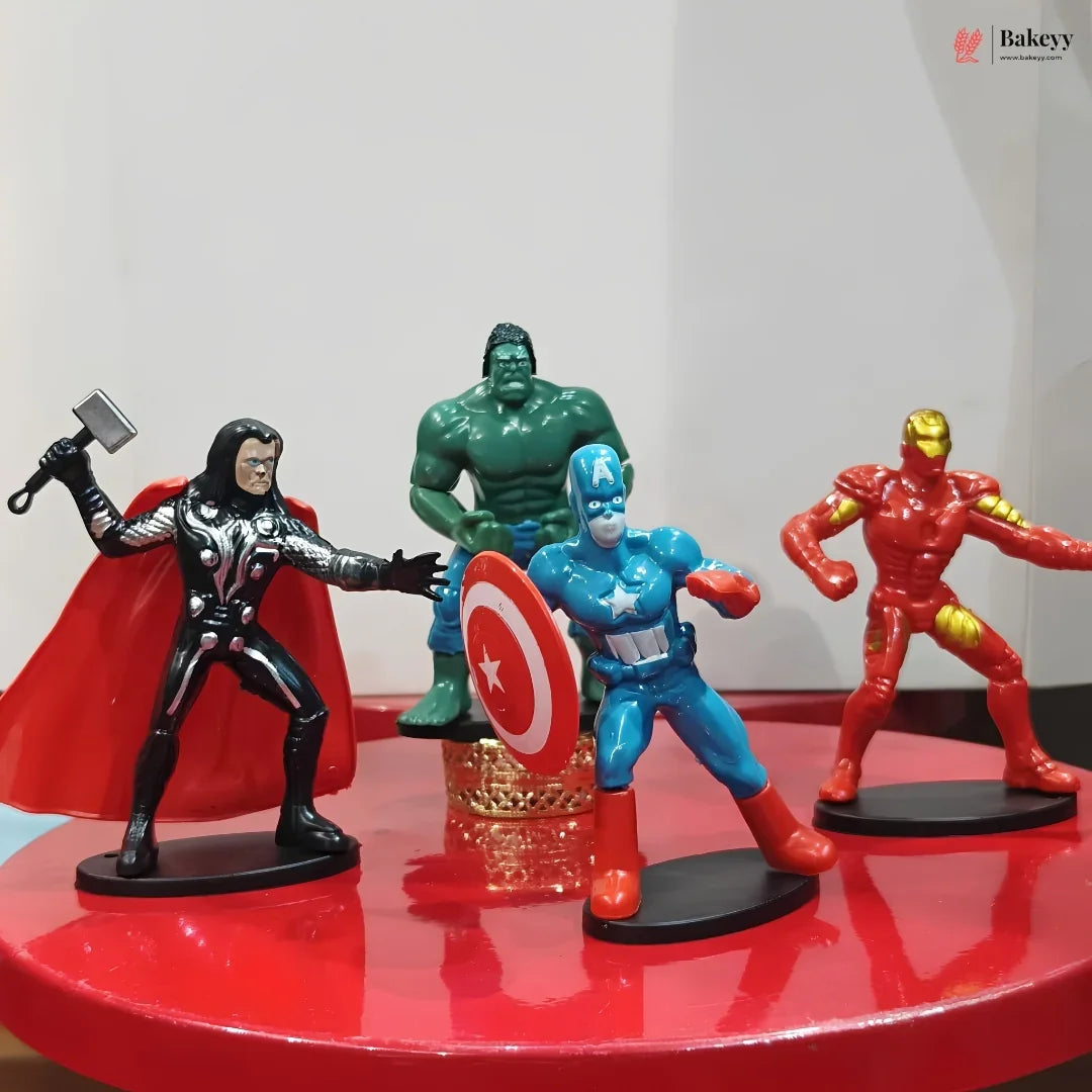 Four superhero figurines on a red surface with a white background