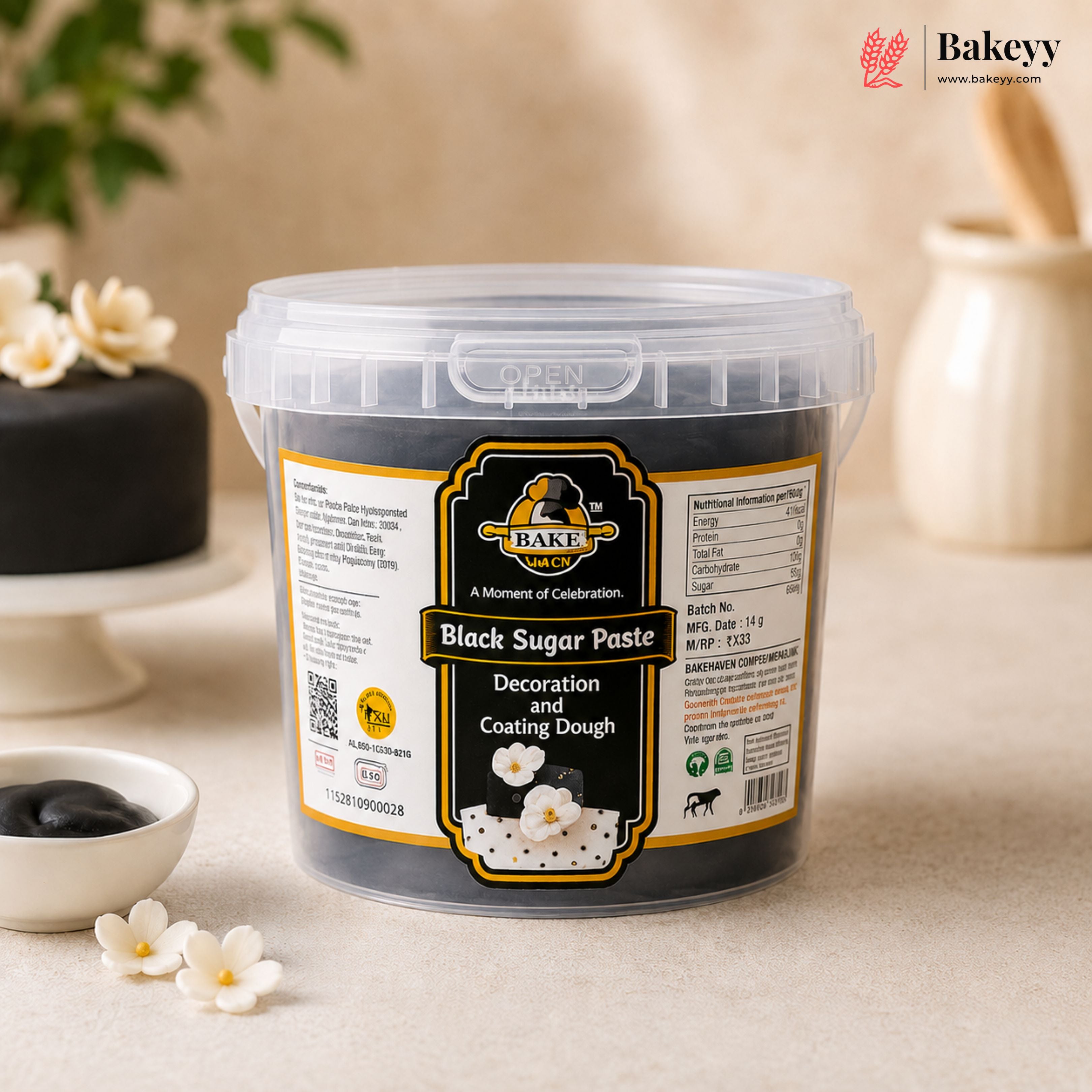 Container of black sugar paste with a visible label on a light background