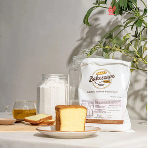 Bakescape cake flour bag with a loaf of bread and a glass of tea on a table.