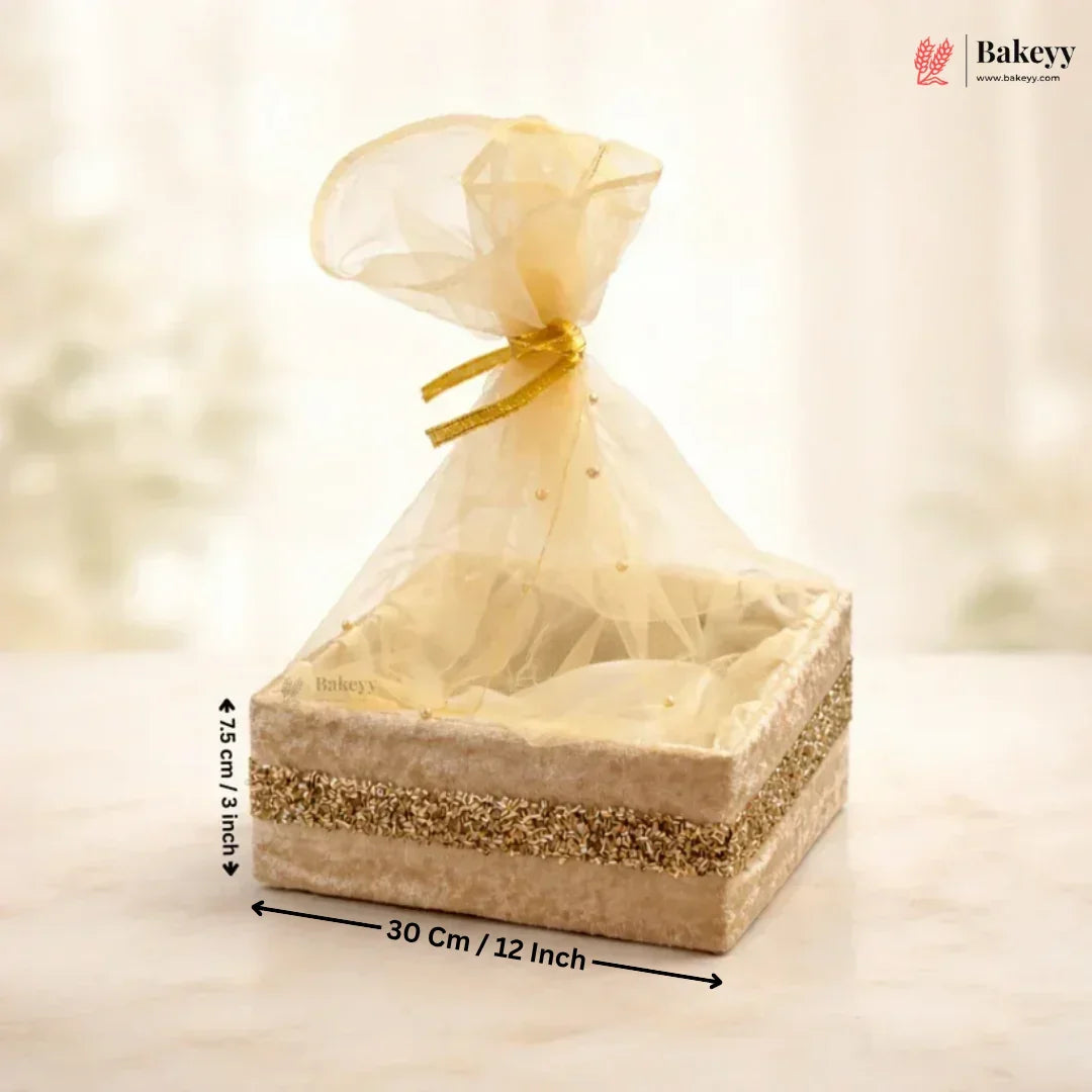 Bakery gift box with sheer gold cover and measurements on a soft background