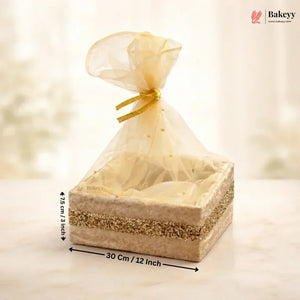 Bakery gift box with sheer gold cover and measurements on a soft background