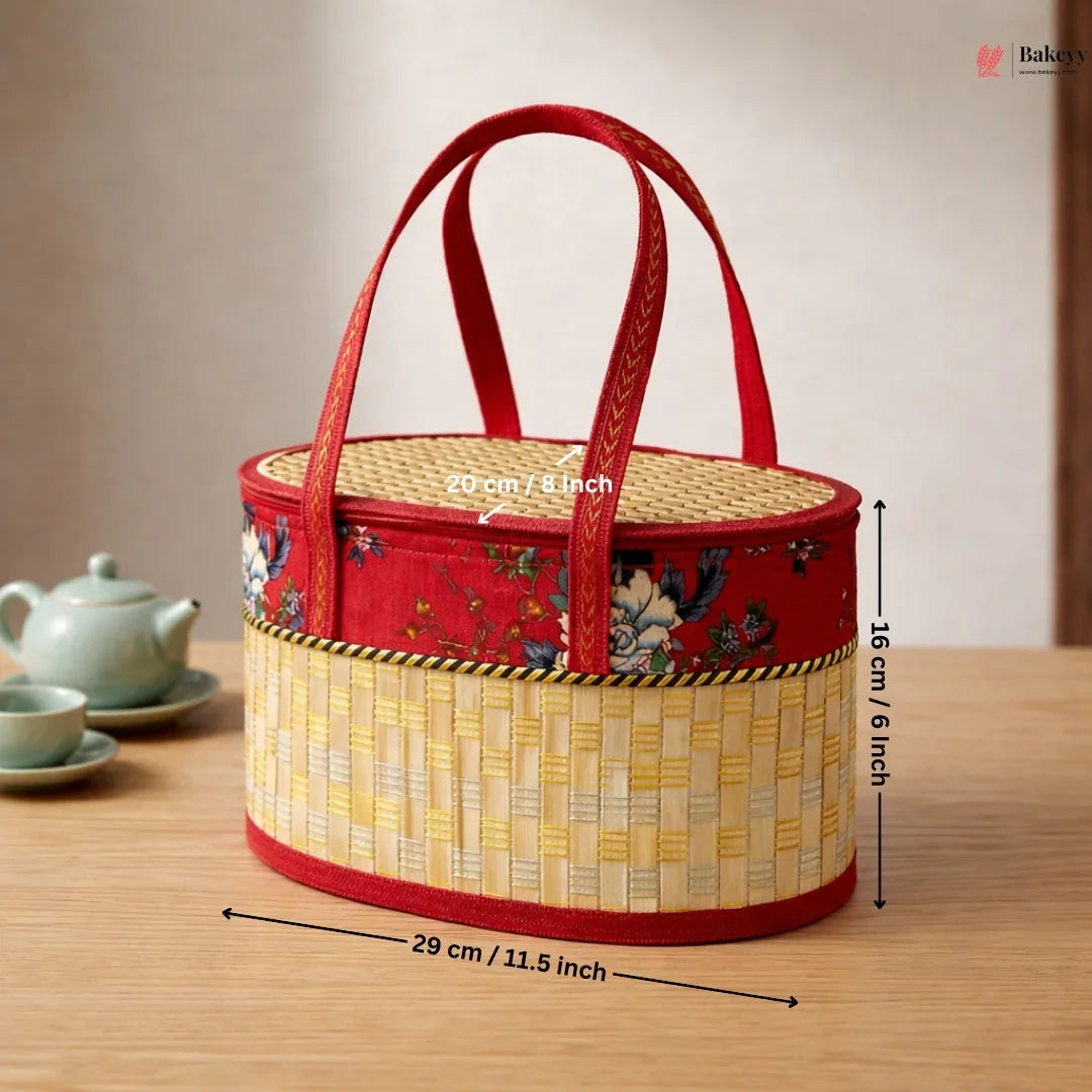 Beige wooden oval basket with metallic weave, red floral fabric, and handles on a table
