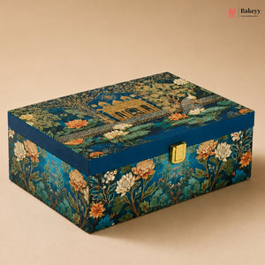 A rectangular decorative box with a blue floral and architectural print, featuring a gold clasp on the front, photographed on a beige background.