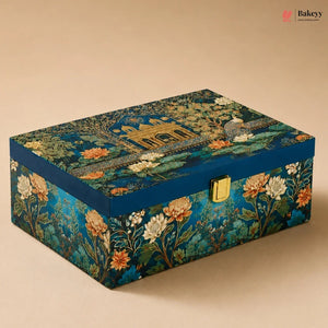 A rectangular decorative box with a blue floral and architectural print, featuring a gold clasp on the front, photographed on a beige background.