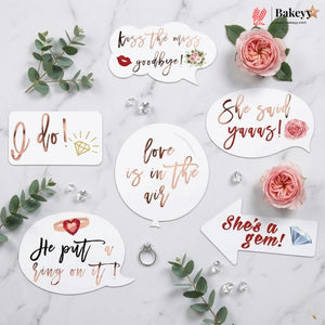 Decorative stickers with romantic phrases on a marble surface with flowers and jewelry.