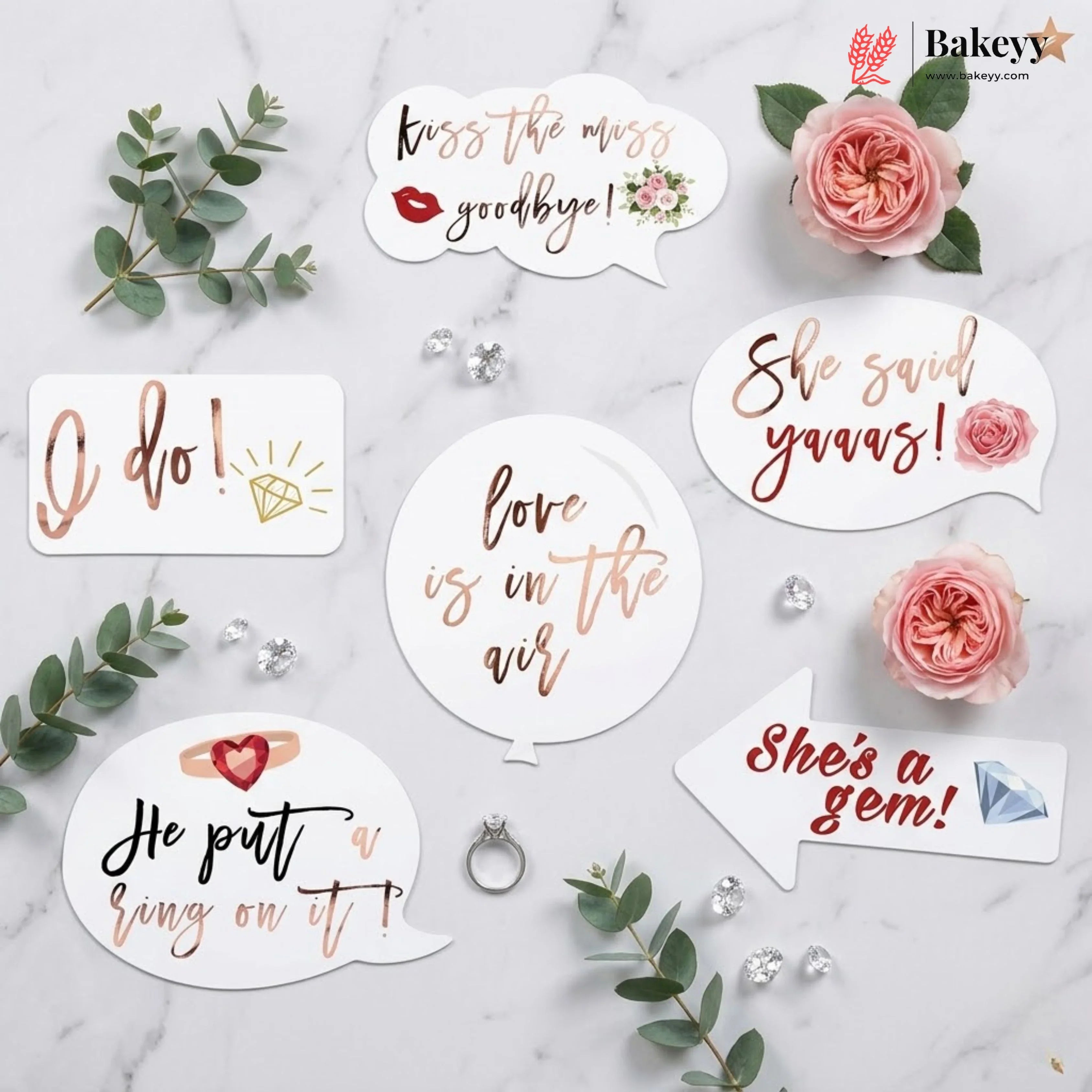 Decorative stickers with romantic phrases on a marble surface with flowers and jewelry.