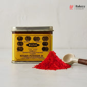 Yellow canister of Bush Kesari Powder IH with red powder and a spoon on a light gray background.