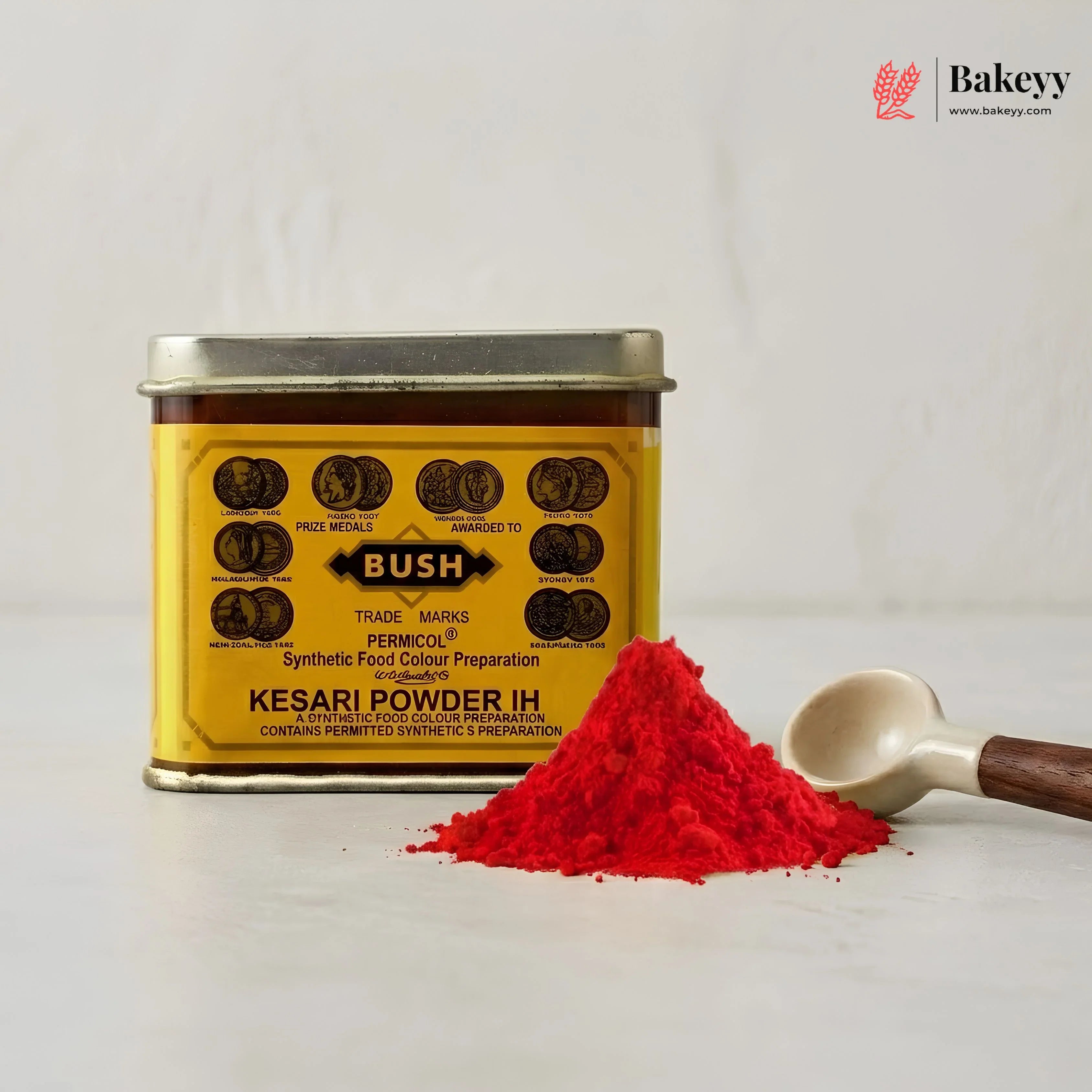 Yellow canister of Bush Kesari Powder IH with red powder and a spoon on a light gray background.