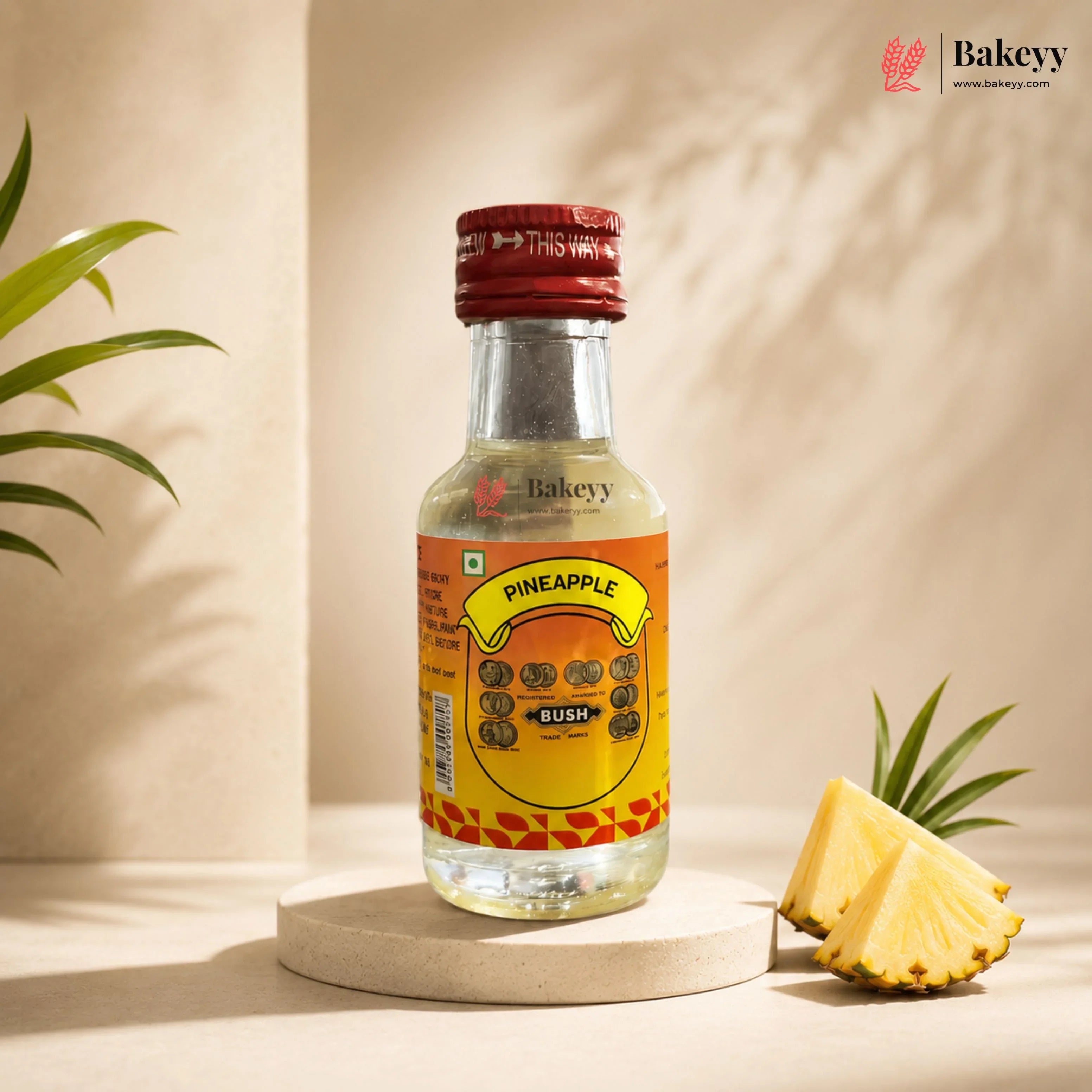 Bottle of Bakeyy Pineapple Bush with a pineapple wedge on a neutral background