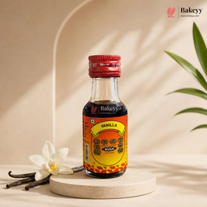 Bottle of Bakeyy Vanilla Bush on a beige background with vanilla beans and flowers.