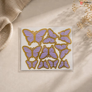 Butterfly-shaped stickers with gold and purple design on a beige surface.