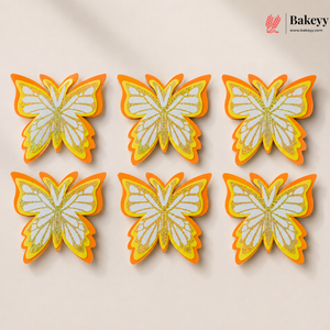 Butterfly-shaped cookies with orange and yellow accents on a beige background, branded 'Bakeyy'.