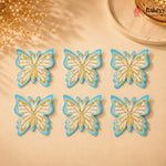 Six butterfly-shaped cookies with gold and blue design on a beige surface, branded 'Bakeyv'.