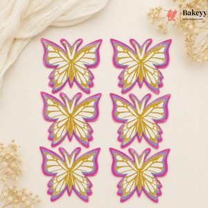 Set of butterfly-shaped decorations with gold and pink outlines on a beige background, featuring the brand 'Bakeyy'.