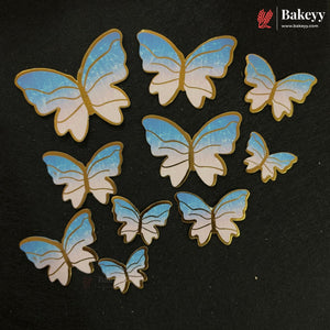Ten butterfly-shaped embellishments in various sizes, featuring a blue and white gradient wing design with gold outlines, arranged on a dark textured background. The Bakeey brand logo is visible in the top right corner.