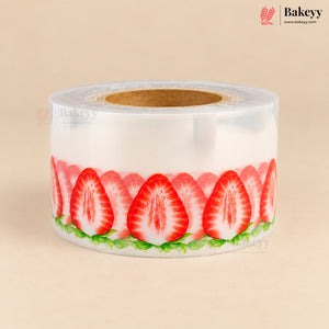 A roll of clear plastic stretch wrap featuring a printed pattern of sliced red strawberries with green leaves, shown on a beige background.