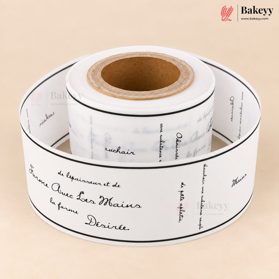A roll of white bakery labels printed with elegant black cursive script and thin black border lines, displayed on a warm beige background. The Bakeey brand logo is visible in the top right corner.