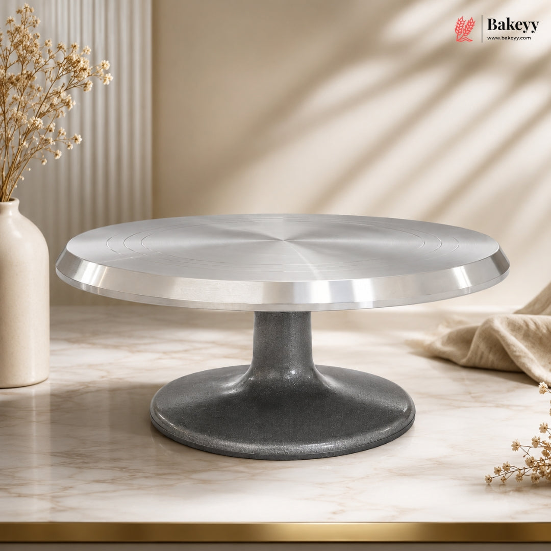 Cake stand on a marble surface with decorative elements and 'Bakeyy' branding.