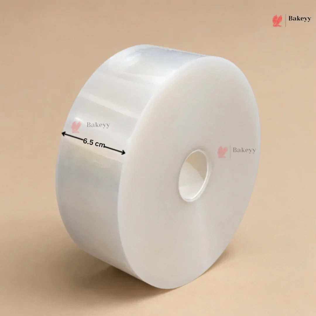 A roll of clear plastic wrap or cellophane with a central hole, shown on a beige background with a black measurement arrow indicating a 6.5 cm width.