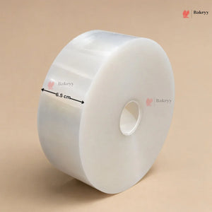 A roll of clear plastic wrap or cellophane with a central hole, shown on a beige background with a black measurement arrow indicating a 6.5 cm width.