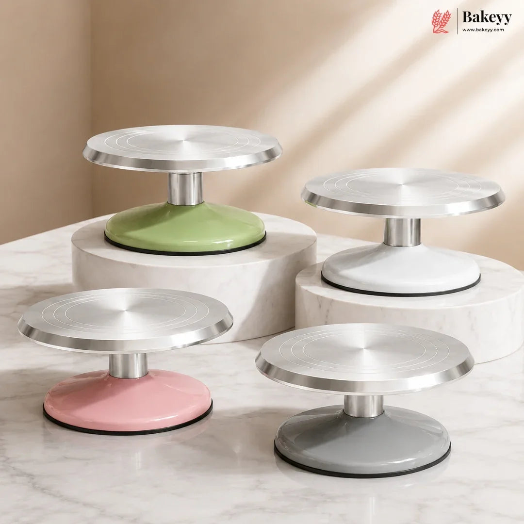 Set of four cake stands in different colors on a marble surface with a beige background.