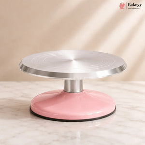 Pink and silver cake turntable on a beige background with 'Bakeyy' branding.