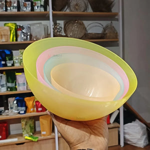 Stack of colorful plastic bowls held in front of a store shelf.