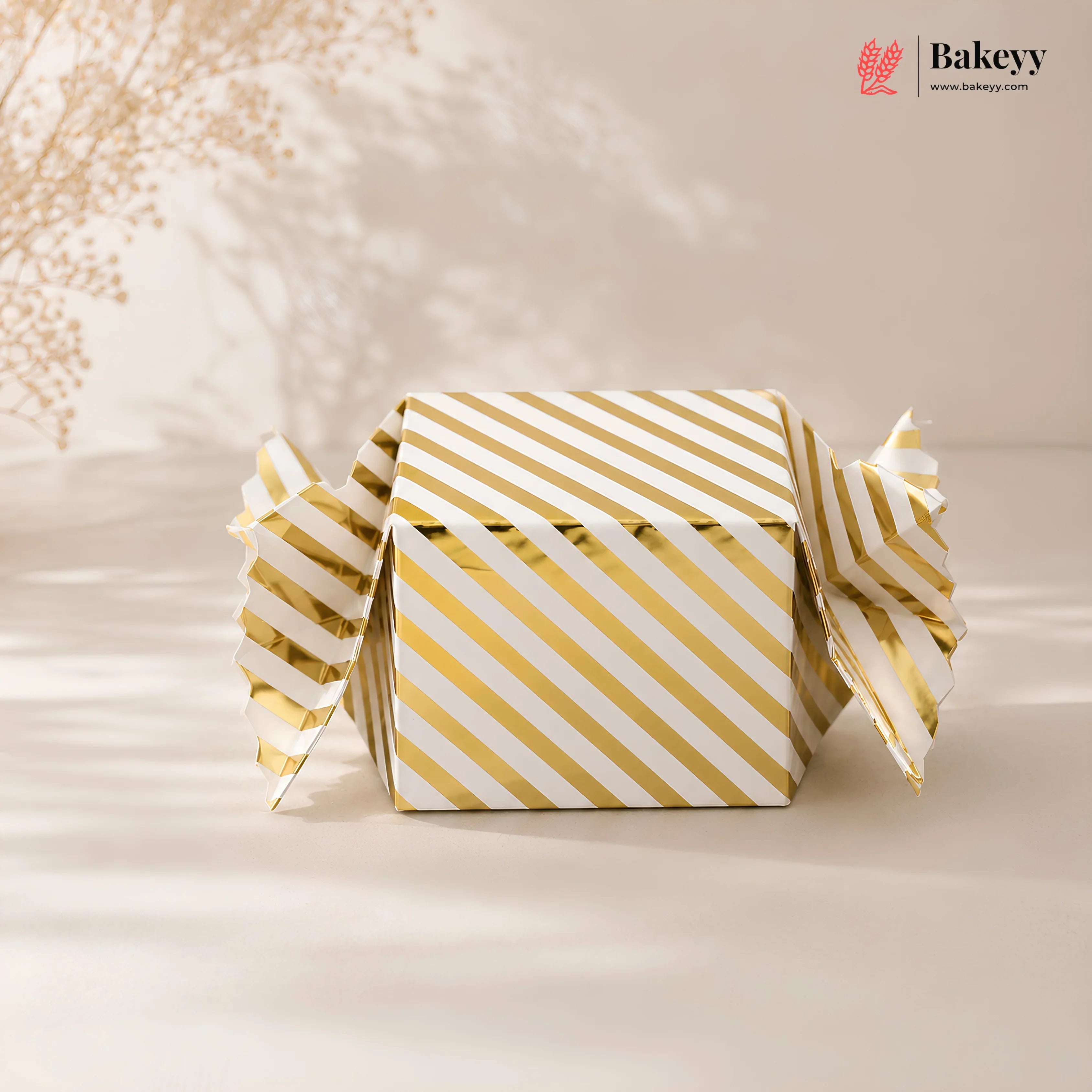 Gold and white striped box with 'Bakeyy' branding on a beige background