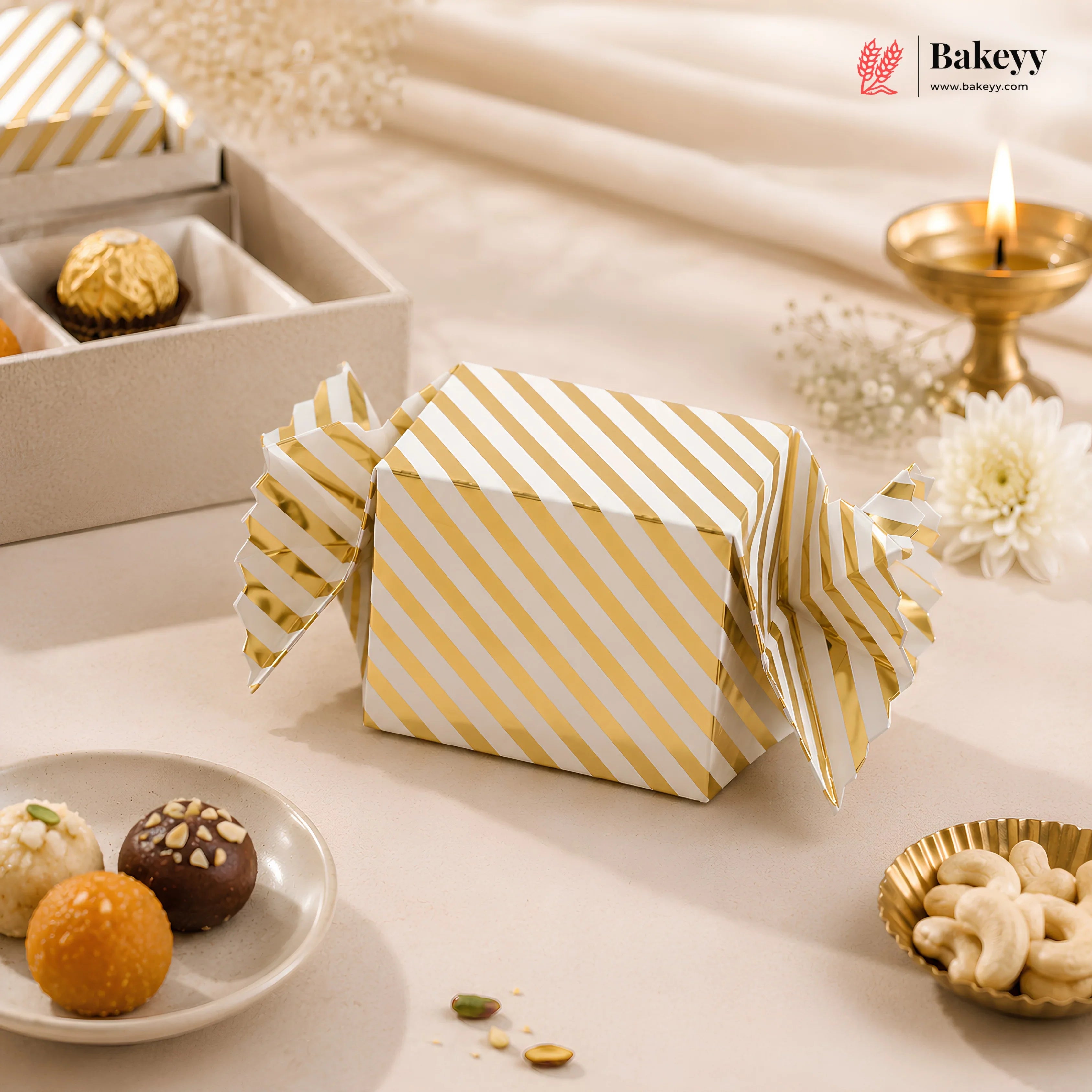 Gold and white striped gift box on a decorative table with snacks and a candle.