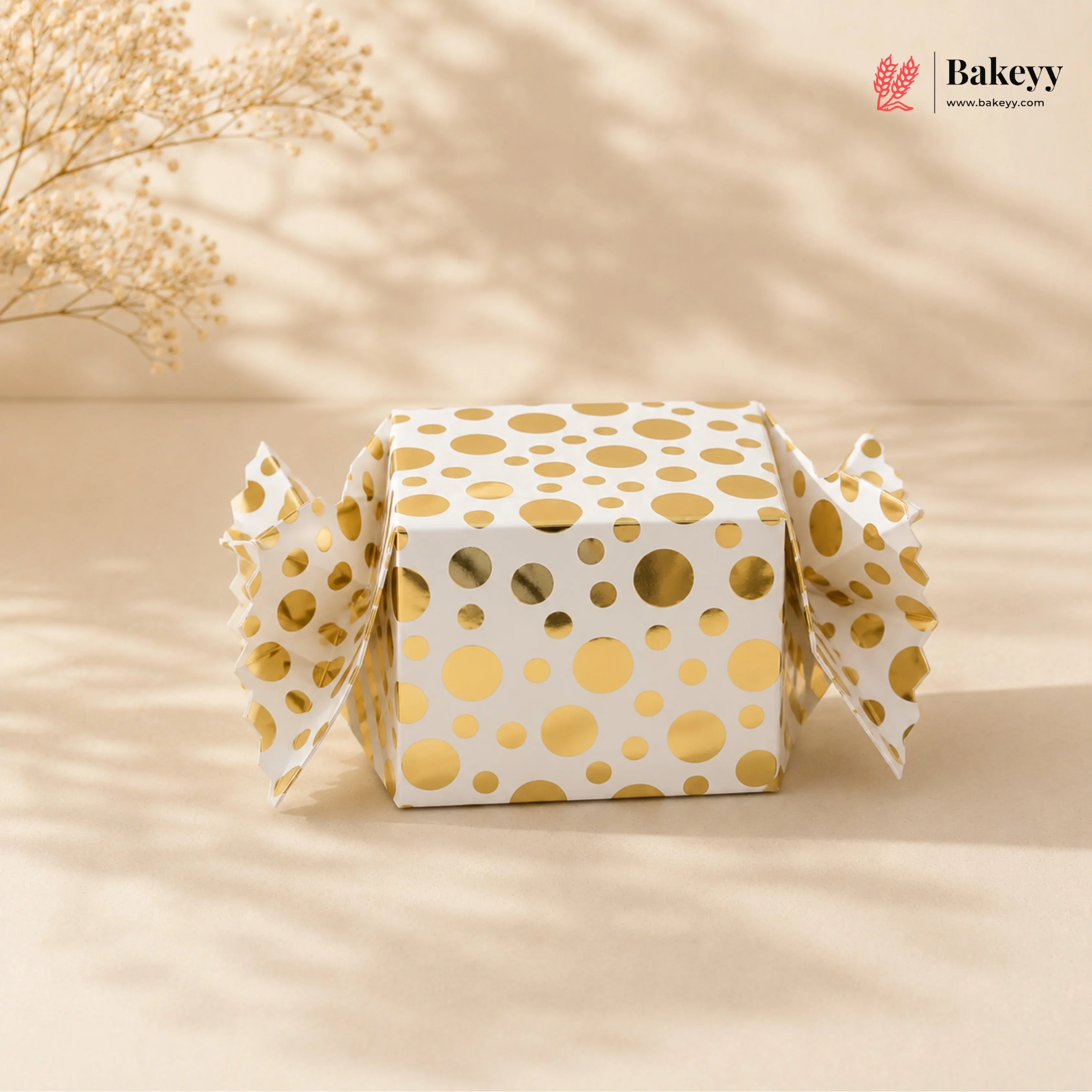 Gift box with gold polka dots on a beige background, featuring the Bakeyy brand.