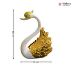 Decorative cake with swan and heart design on a marble surface, featuring the Bakeyy brand.
