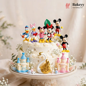Decorative cake with cartoon character figurines and castle decorations on a stand.