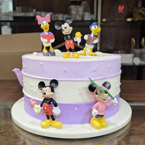 Two-layer cake with cartoon character figures on a wooden table.
