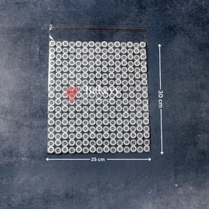 Packaging with a grid of small round items and a red heart on a textured dark background