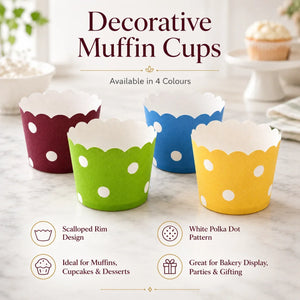 Decorative muffin cups in red, green, blue, and yellow with scalloped rim and white polka dot pattern on a marble surface.