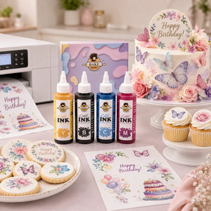Edible ink bottles and printed items on a table with a decorated cake and cookies.