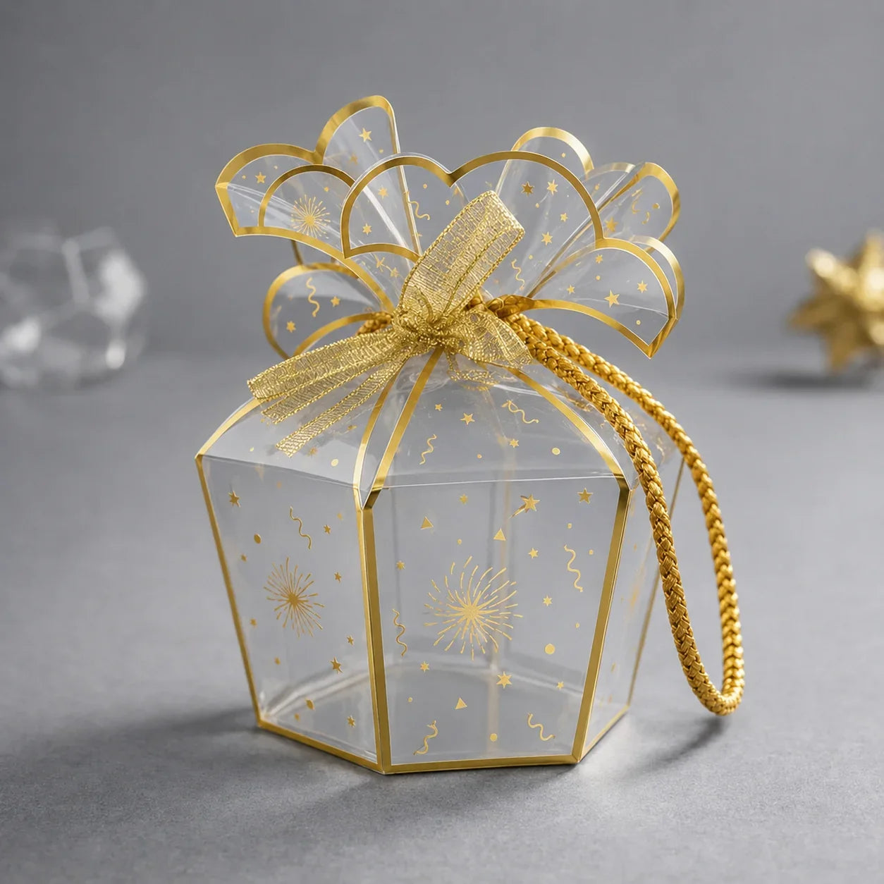 Clear gift box with gold decorative bow on a gray background