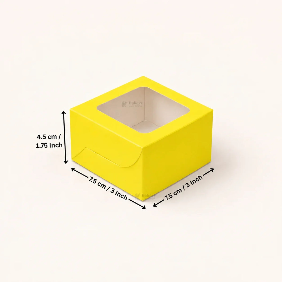 A bright yellow square paper box with a clear window on top, shown on a light beige background with black dimension arrows and text indicating 7.5 cm / 3 inch by 7.