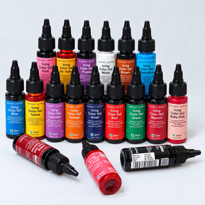 A set of small bottles of Royal Pro icing color gel, arranged in rows on a light gray background, with three bottles lying on their sides in front. The bottles contain various colored gel and are labeled with names like Blue, Yellow, Purple, White, Brown, Baby Blue, Red, Green, Maroon, Pink, and Lavender.