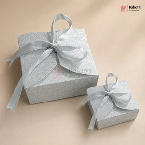 Two silver gift boxes with ribbons on a beige background, featuring the Bakey brand.