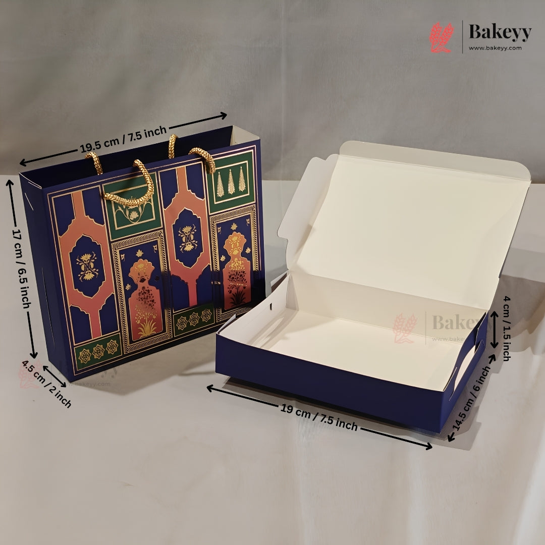 A navy blue bakery gift bag and matching open cardboard box with printed ornate arch motifs, shown on a white surface with dimension arrows and labels. The Bakeyy logo appears in the top right.