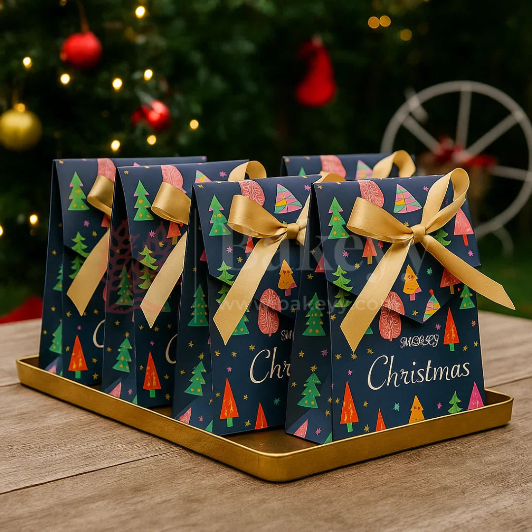 Christmas-themed gift boxes with ribbons on a tray in front of a decorated Christmas tree.