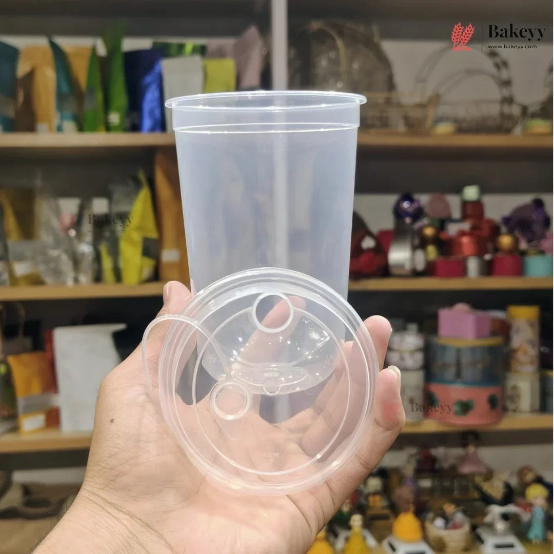 Clear plastic cup with lid held in front of a store shelf