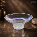 Clear glass bowl on a dark surface with a blurred background
